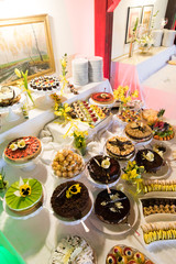 Gustownie nakryte i udekorowane stoły ciastami i ciasteczkami z okazji uroczystości rodzinnych lub spotkań okolicznościowych - obrazy, fototapety, plakaty