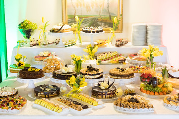 Gustownie nakryte i udekorowane stoły ciastami i ciasteczkami z okazji uroczystości rodzinnych lub spotkań okolicznościowych - obrazy, fototapety, plakaty