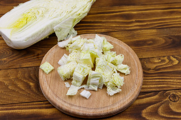 Chopped chinese cabbage on cutting board on wooden table