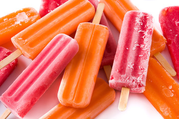Orange and strawberry popsicles isolated on white background.