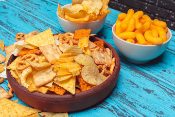 Beer snacks like crackers, chips, cookies on a wooden surface