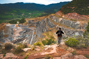 Adult man looking at a stone quarry.