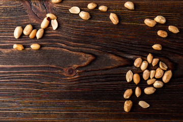 Chocolate bar with caramel and peanut on dark wooden background. 