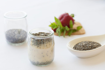 Healthy vegan chia pudding in a jar with fresh strawberry on the table
