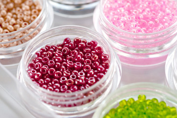 Set of multicolored beads for embroidery and needlework in plastic jars