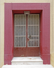 weathered vintage house entrance door with colorful frame, Plaka old neighborhood,  Athens Greece