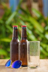 Brown beer bottles on a table on a green background
