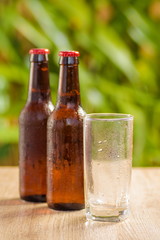 Brown beer bottles on a table on a green background