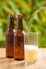 Brown beer bottles on a table on a green background