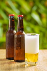 Brown beer bottles on a table on a green background