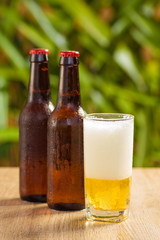 Brown beer bottles on a table on a green background
