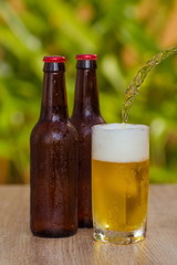 Brown beer bottles on a table on a green background