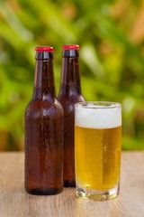 Brown beer bottles on a table on a green background