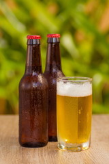 Brown beer bottles on a table on a green background