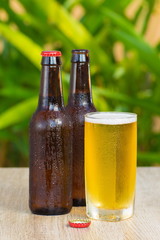 Brown beer bottles on a table on a green background