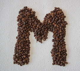 Image of roasted coffee beans shaped alphabet on a white background