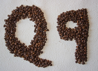Image of roasted coffee beans shaped alphabet on a white background