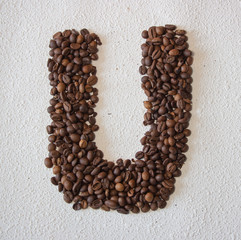Image of roasted coffee beans shaped alphabet on a white background