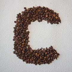 Image of roasted coffee beans shaped alphabet on a white background