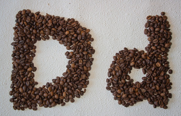 Image of roasted coffee beans shaped alphabet on a white background
