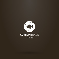 white logo on a black background. simple vector round negative space round logo of fish swimming in water