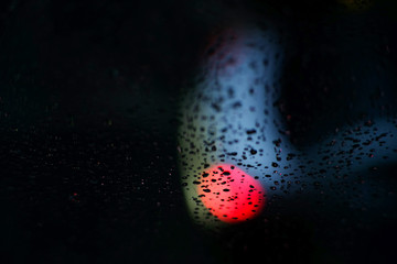 drop of rain on glass with bokeh in the night