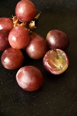juicy ripe grapes on a black table top