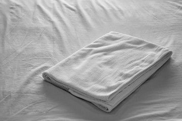 Obraz premium White towel on bed in bedroom