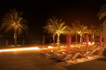 Night views of the beach, palm trees, sun beds and sea