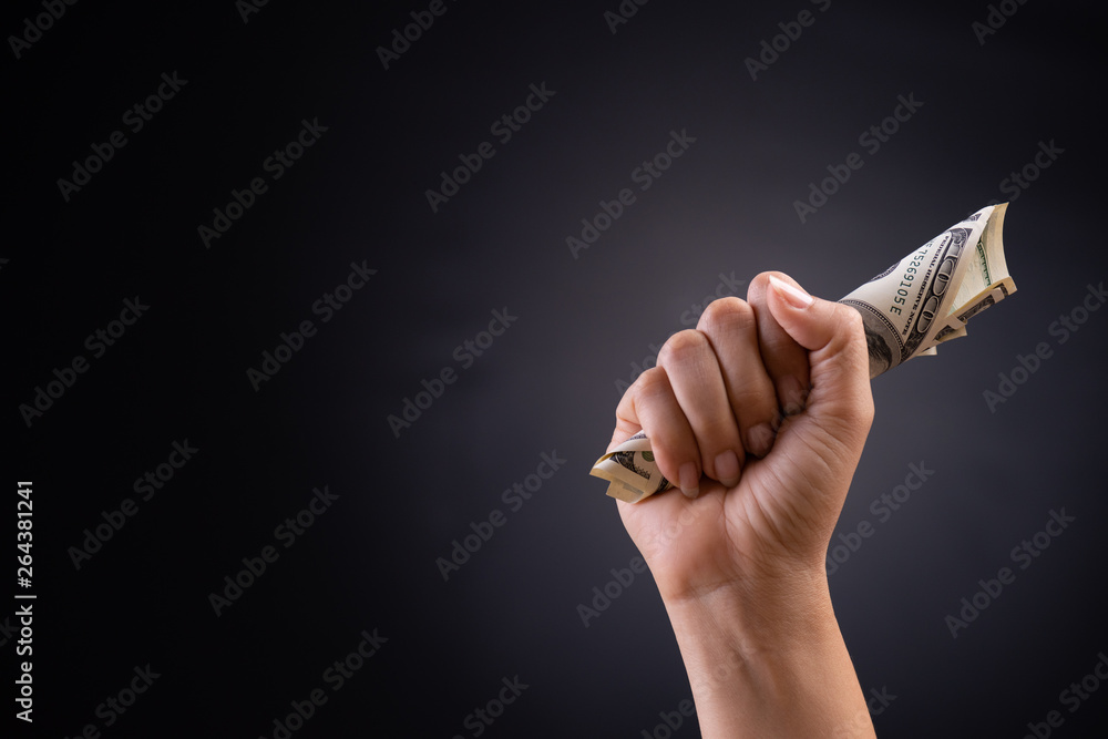 Wall mural close up woman hand holding american dollar in the dark background. business finances, savings and b