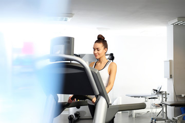 Running on the treadmill.  The woman runs on an automatic treadmill