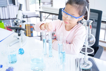Asian Thai Children scientists making experiments chemical with looking microscope in the laboratory room.Science and education concept