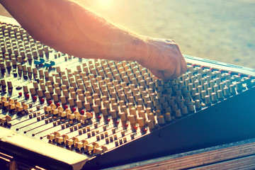 audio engineer working on the mixer, sound operator at the console in a live music show