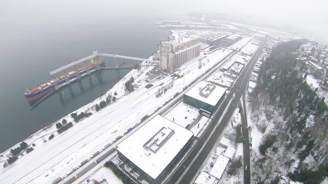Cold Winter Snow Aerial of Seattle Waterfront Indstrial Building and Ship