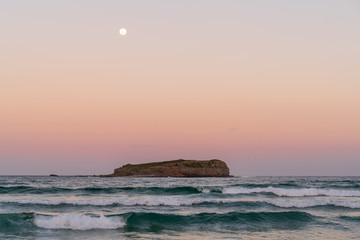 Vollmond &uuml;ber der Cook Island bei Sonnenuntergang und starkem Wellengang