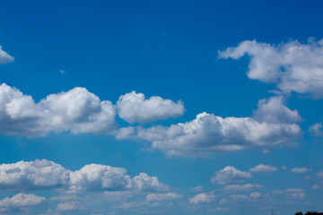 Naklejka na ściany i meble Big white fluffy clouds in the blue sky.Summer background.