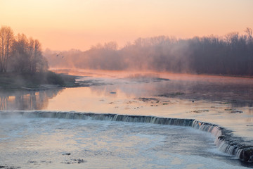 Fototapeta premium View of the Rumba Falls in the city of Kuldiga, Latvia. Early spring morning. 