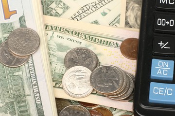 Calculator on banknotes with a pen and pencil. Limited depth of field