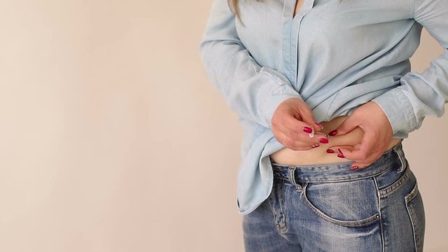 Close-up of a girl with type 1 diabetes makes a subcutaneous injection of insulin into the stomach at home. The concept of diabetes. Insulin therapy.