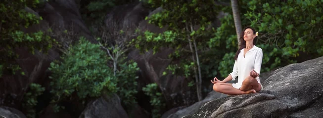 Fotobehang Woman Practicing Lotus Pose Enjoying Nature © Pasko Maksim 