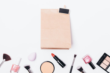 Brown paper bag near women's decorative cosmetics