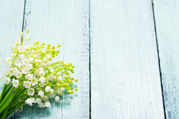 bunch of lily of the valley flowers on faded blue table