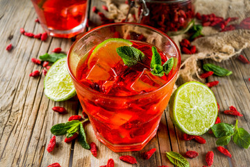 Homemade goji lemonade with lime and mint, rustic wooden background copy space