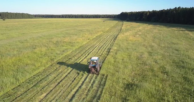 bird eye view old haymaker works on field mowing grown grass against amazing summer nature