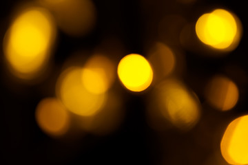 Abstract gold bokeh on black background. Defocused yellow lights, abstract texture
