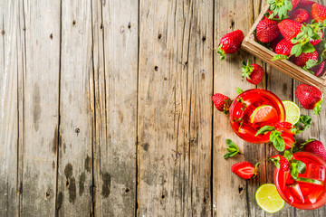 Fototapeta na wymiar Homemade strawberry lemonade with lime and mint, rustic wooden background copy space