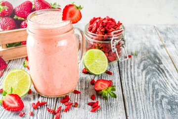 Healthy blended drink. Organic diet smoothie with lime, strawberry and goji berries, wooden...