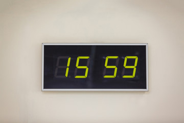 Black digital clock on a white background showing time 15.59 minutes