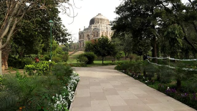 gimbal shot walking along a path at lodhi garden with shish gumbad tomb in the distance, new delhi