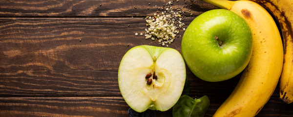 Ingredients fot healthy breakfast detox green smoothie bowl from banana, apples and spinach on wooden background. View from above. Banner